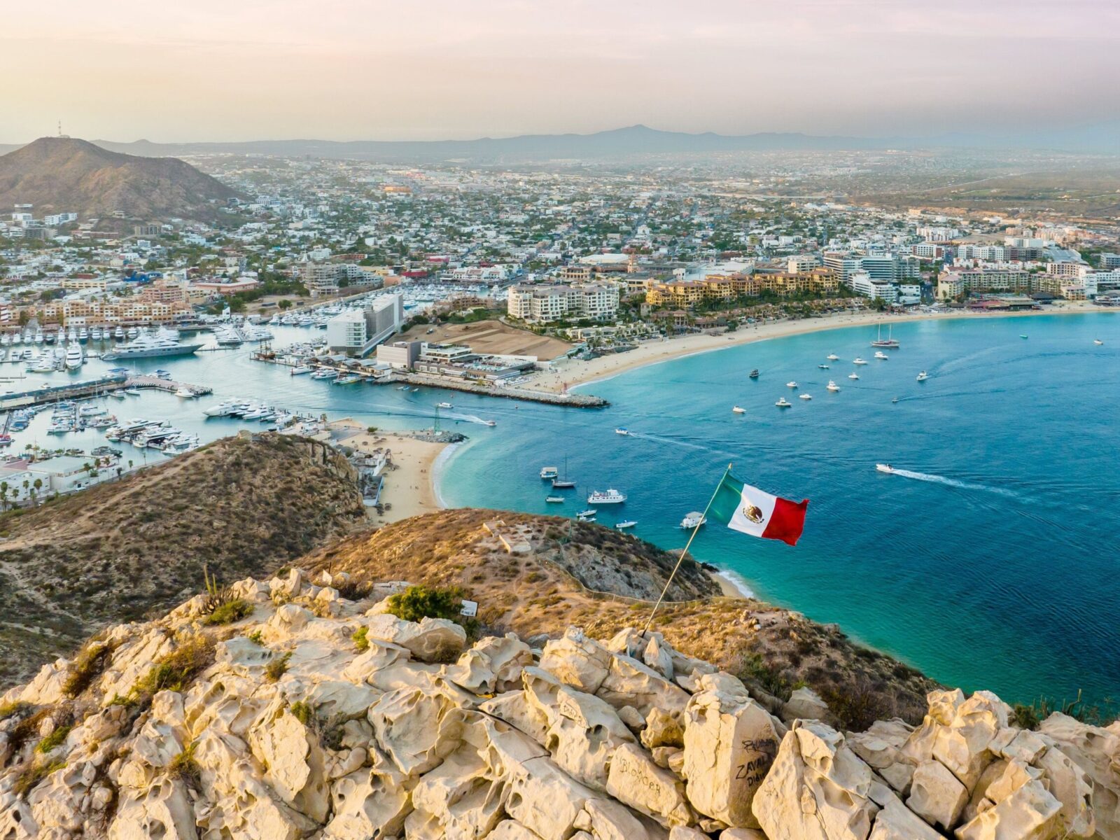 A,Vibrant,Flag,Waving,In,The,Foreground,Of,A,Picturesque