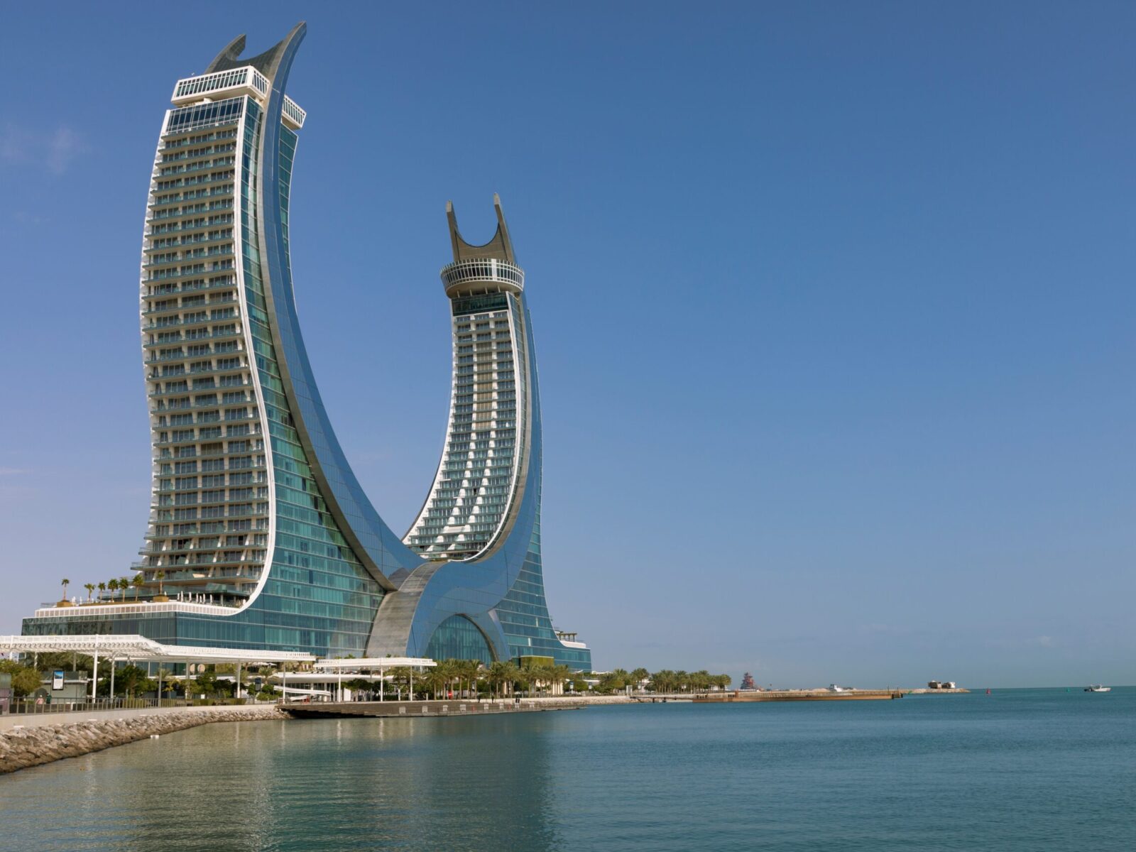 Crescent,Tower,With,Palms,Trees,In,The,Morning,,,Lusail